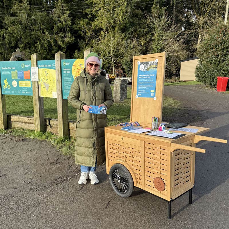 Lady standing beside a handcart
