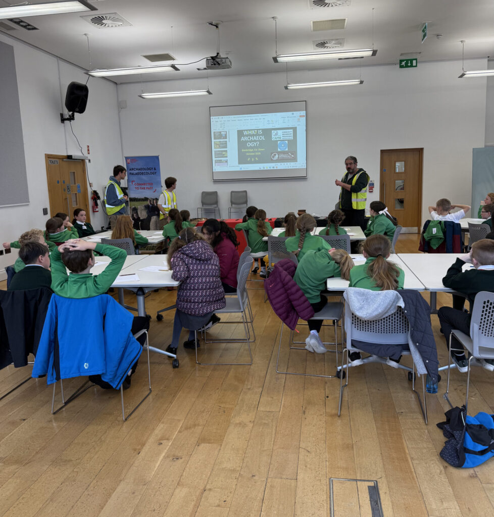 hree individuals taking a session with 30 school children in green uniform