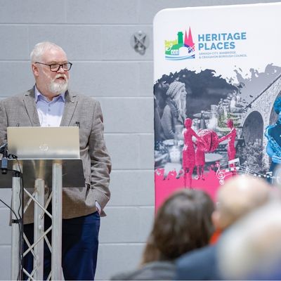 Gentleman speaking with banner behind him