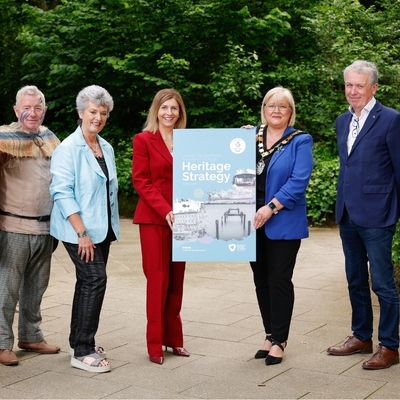 group of figures holding heritage strategy sign